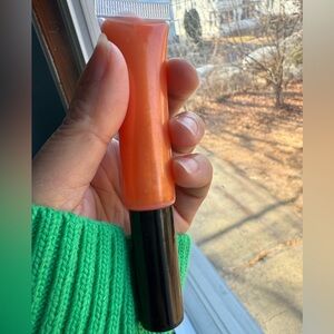 Pastel orange lip gloss perfect for a daytime look.